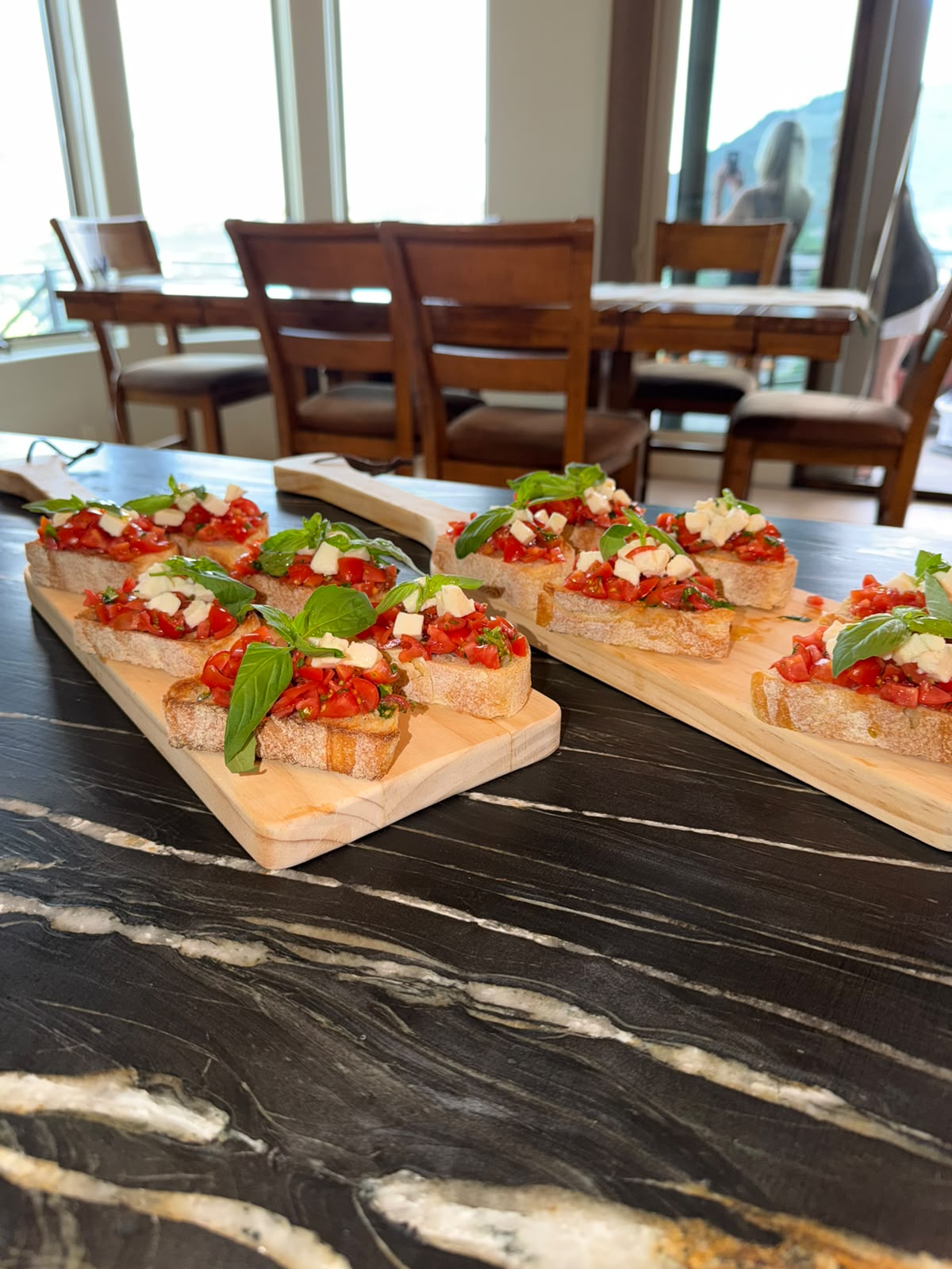 Fresh tomato, cheese and basil bruschetta arranged on wooden boards for a private gathering